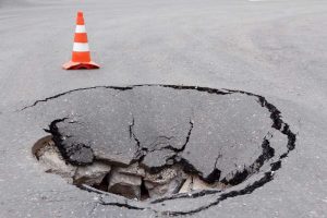 Deep sinkhole on a street city and orange traffic cone Charlotte, NC